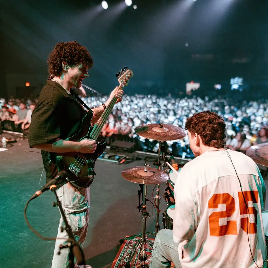 townsend playing guitar next to the drummer in front of a packed arena