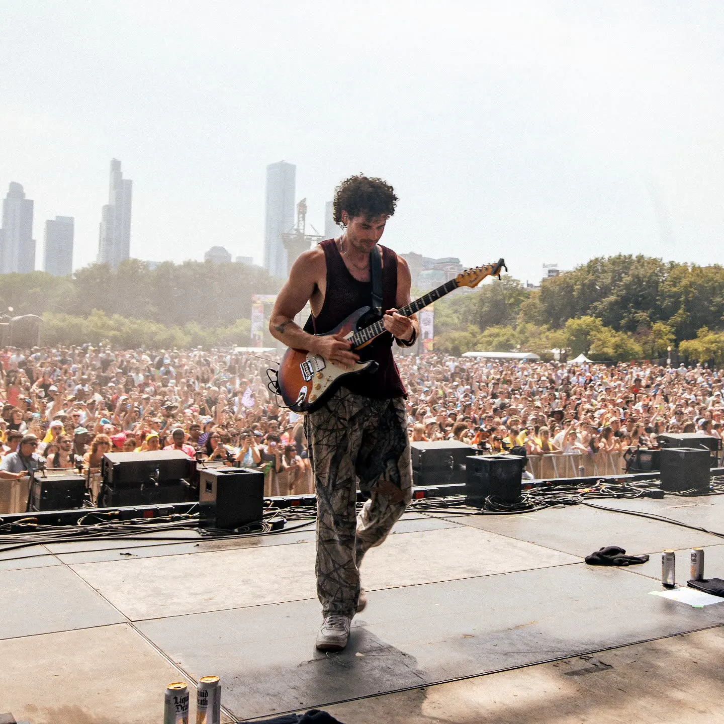 townsend playing guitar on the lollapalooza stage in front of a huge crowd and the chicago skyline